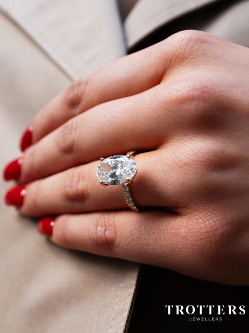 Trotters 18ct Yellow Gold 4ct Lab Grown Oval Diamond Ring With Diamond Set Shoulders & Hidden Diamond Halo